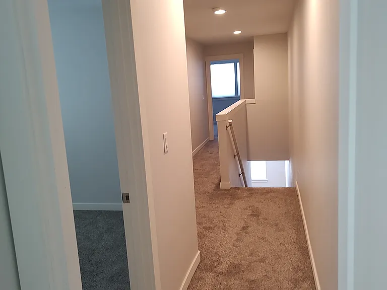 hallway facing stairs and bedroom 1& 2