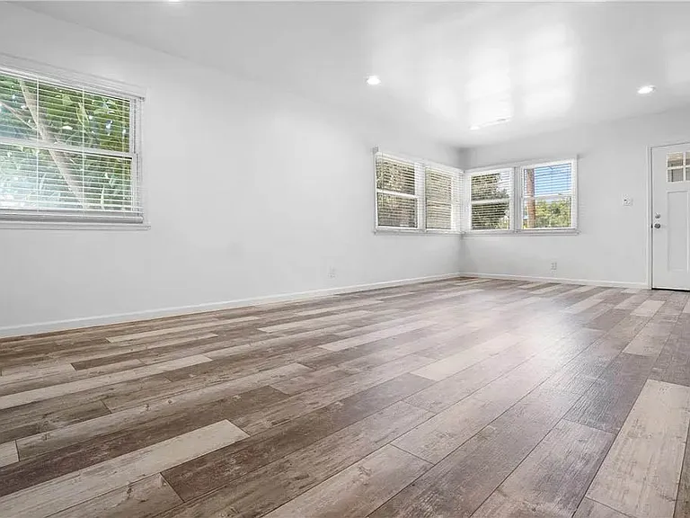 Bright and spacious living room with recessed lights, luxury vinyl plank flooring and more