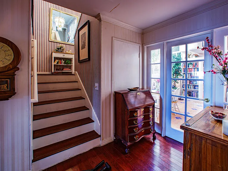 To the right of the french doors is the glass enclosed atrium and to the left the stairs leading to the entryway.