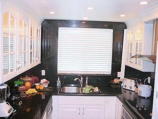 Contemporary style kitchen with granite counters & recessed lighting.