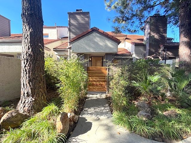 Beautiful front entrance facing pine trees. Gate closure to patio and privacy. Keypad and door camera included.