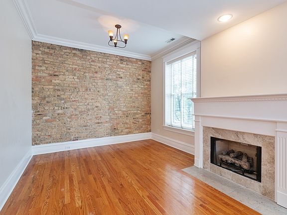 Beautiful exposed brick wall, fireplace, hardwood and crown moldings