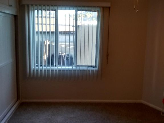 Carpeted Bedroom with ceiling fan & builtin closet with storage above* All windows have been replaced with double pane windows and all verticals have been replaced with sharp solar shades.