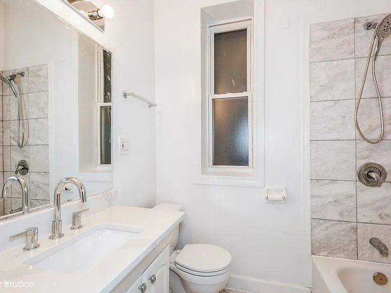 Bathroom with marble floors and shower, quartz countertop, and two large linen cabinets for additional storage