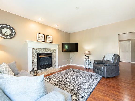 Front door enters into the living room. Fireplace, front closet windows.