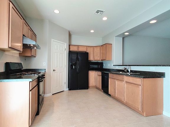 Kitchen with gas stove, vented range hood (860 cfm), fridge, microwave, dishwasher, garbage disposal, and walk in pantry.