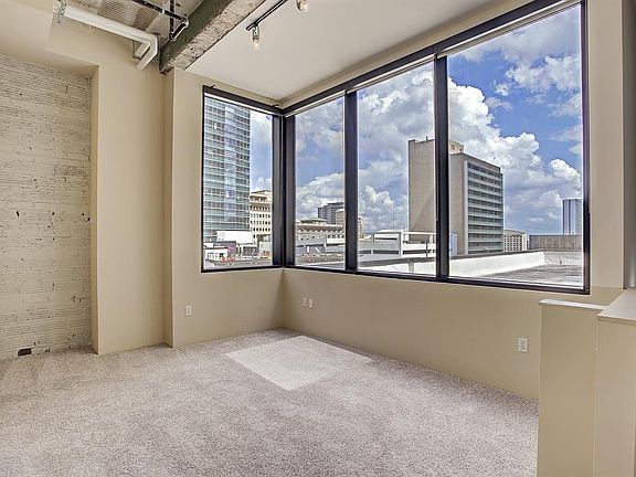 Master bedroom located on the top floor overlooking the city. The master bedroom offers 4 large windows that provide the room with a great amount of natural light! Some might even use this as a terrific living area with views of Minute Maid and watch