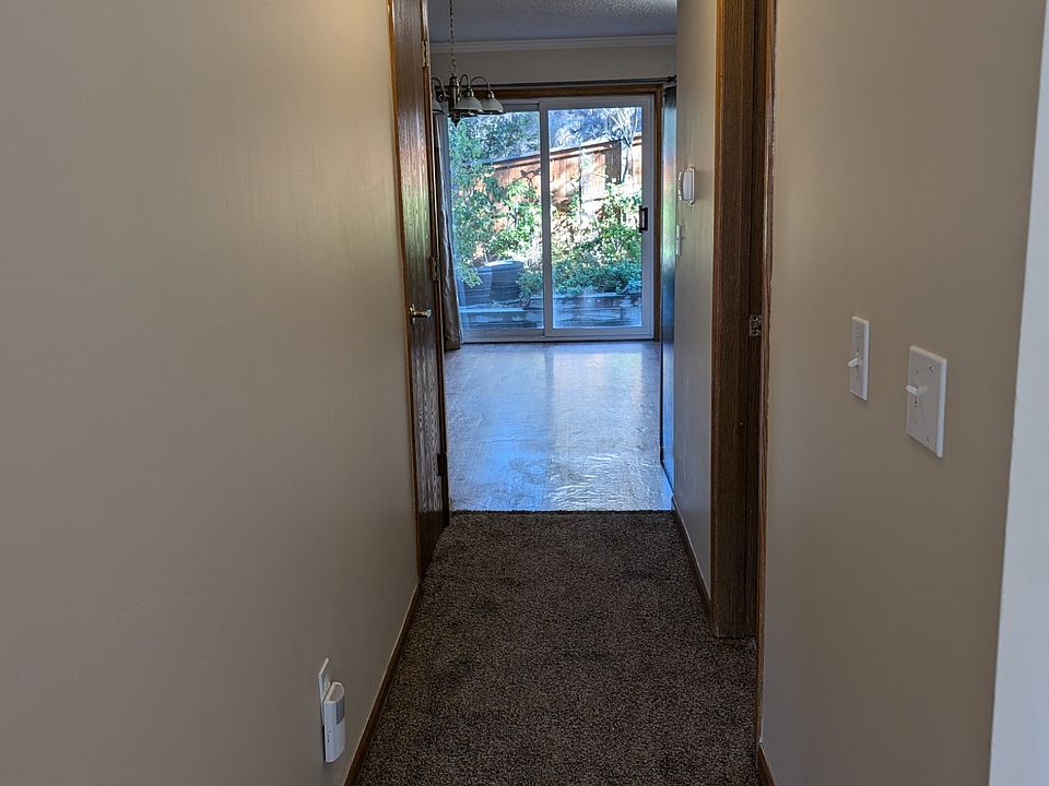 Hallway from living room to 1/2 bath, storage/coat closet, kitchen, and backyard