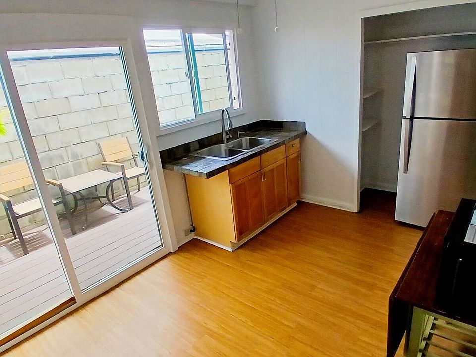 Kitchen area includes a full size refrigerator, microwave and sink.
