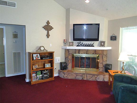 Den area has corner fireplace and vaulted ceiling.