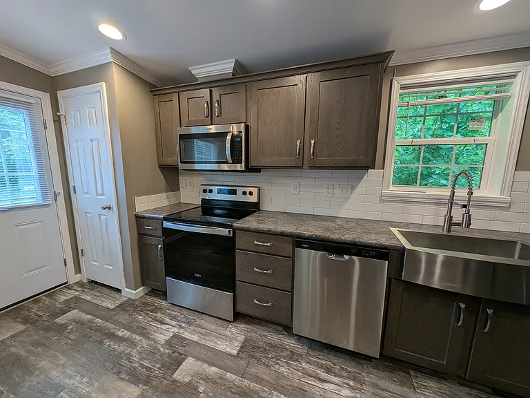 Electric stove with microwave with exhaust fan to outside. Also side entrance and a small breakfast nook.