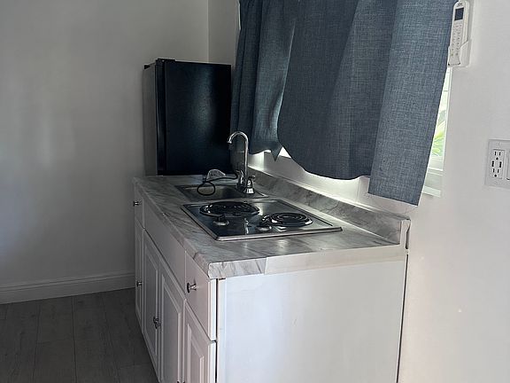 Kitchenette with electric stove and small sink for washing dishes