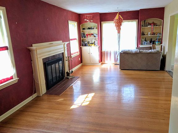 Sunlit Living room with working fireplace and built-in bookcases and cupboards.