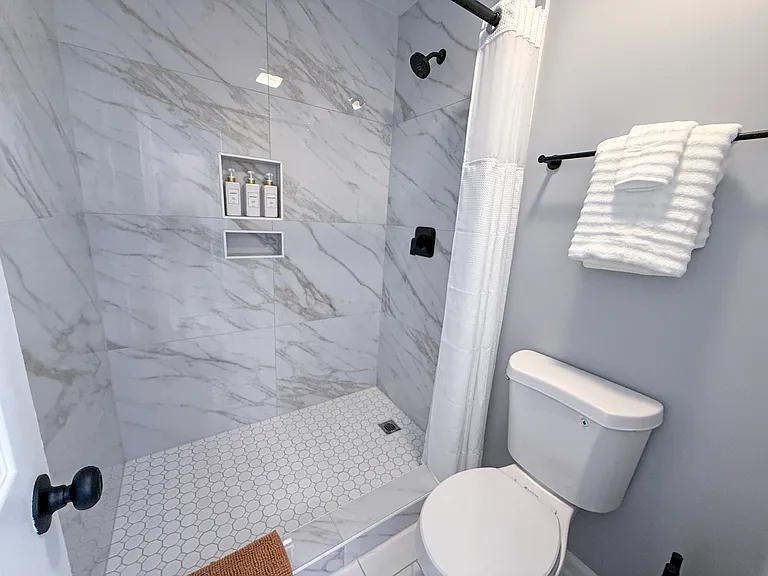 Upstairs guest shower/toilet room with updated tile and fixtures