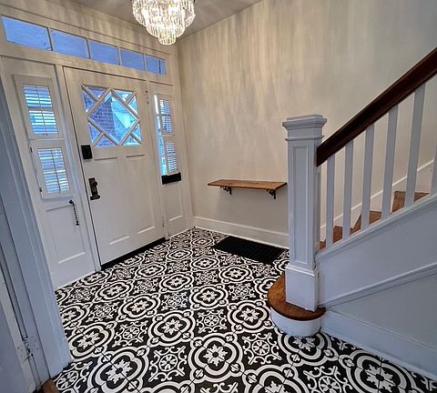 Entryway with brand new Italian tile, refinished hardwood stairs, and a brand new chandelier.
