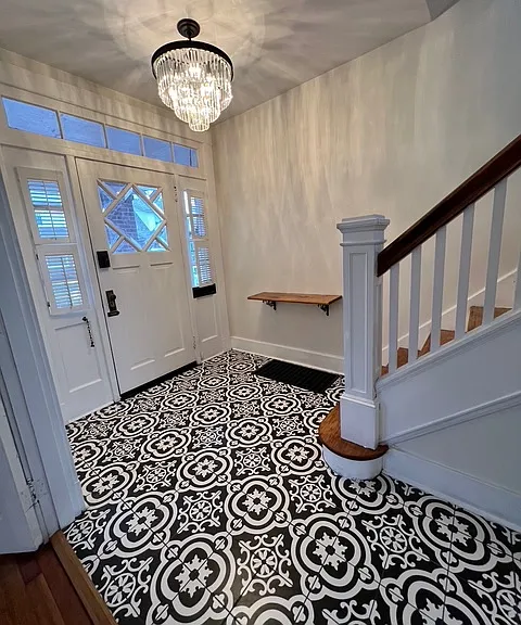 Entryway with brand new Italian tile, refinished hardwood stairs, and a brand new chandelier.