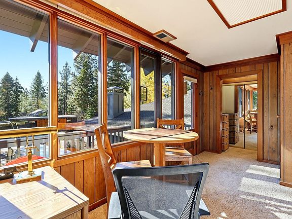 Desk and table face a sunny deck and filtered view of Lake Tahoe