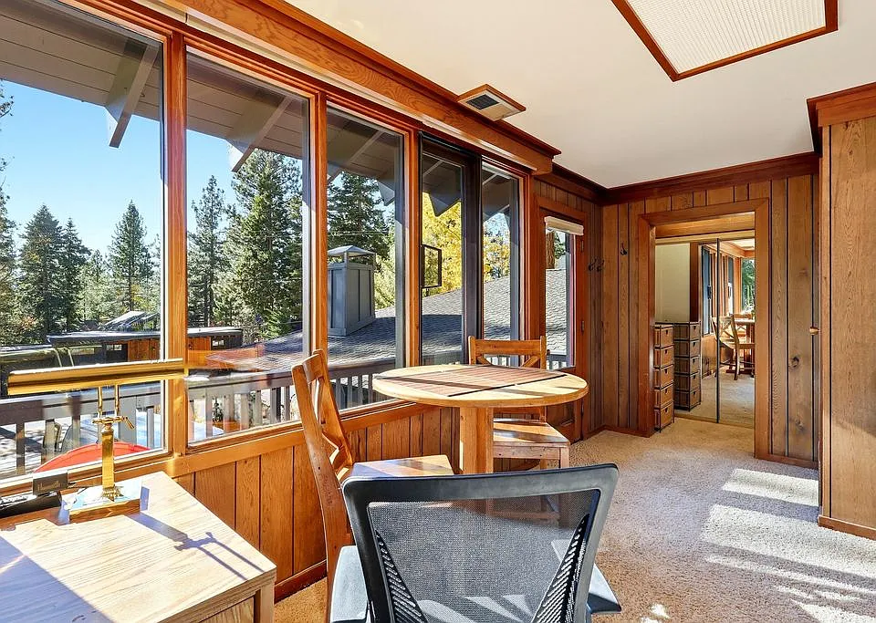 Desk and table face a sunny deck and filtered view of Lake Tahoe