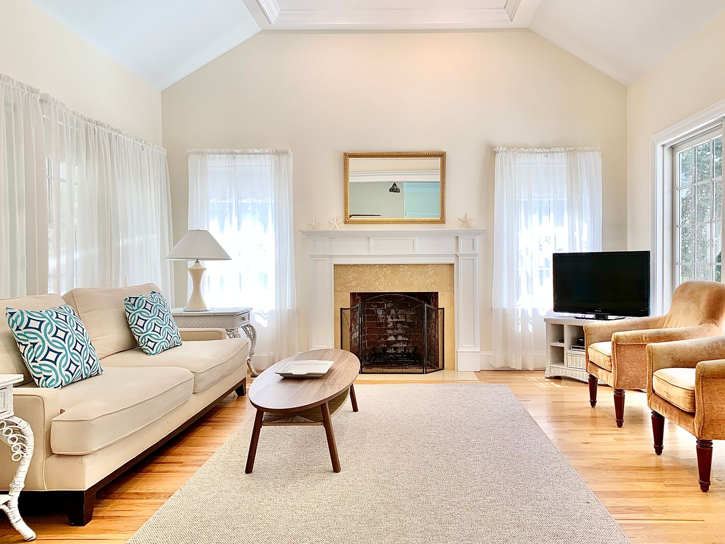  Sunlit living room with cathedral ceilings, sliding doors, fireplace, and flat screen tv
