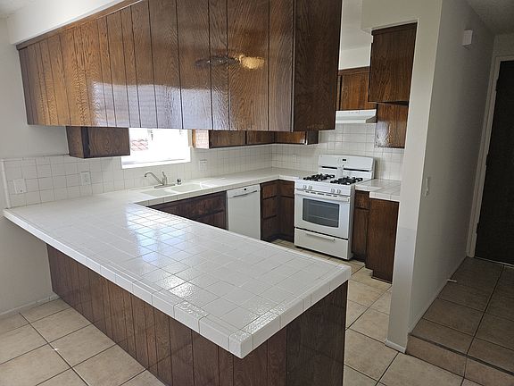 Large kitchen with tiled countertops.