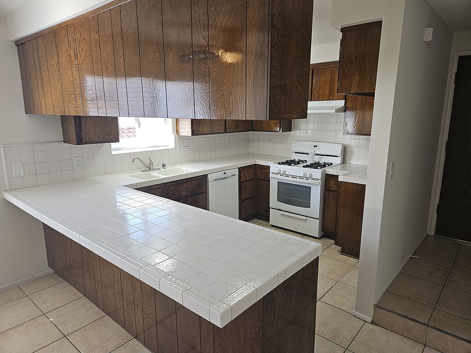 Large kitchen with tiled countertops.