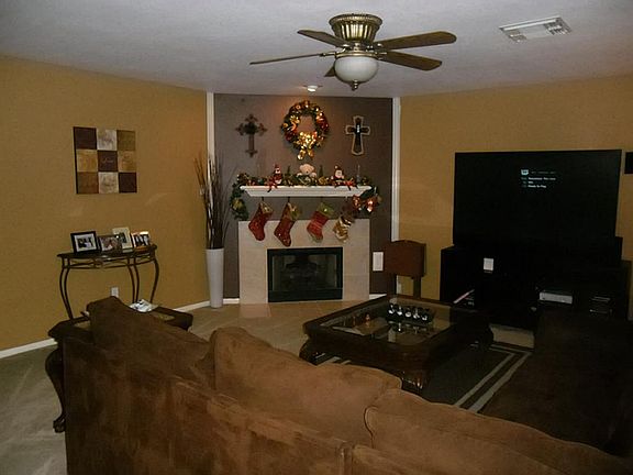 Large & homey den with designer paint, corner fireplace & view to kitchen & dining