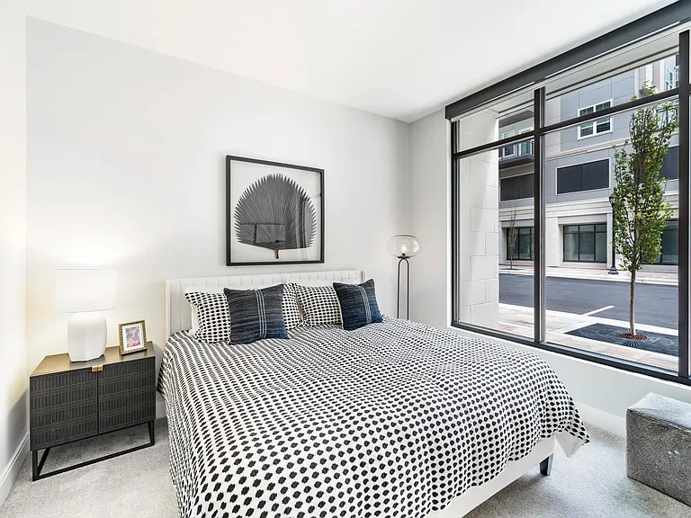 Retreat to bright, airy bedrooms at Modera Liberty Row, where expansive windows and calming design create a peaceful Charlotte escape.
