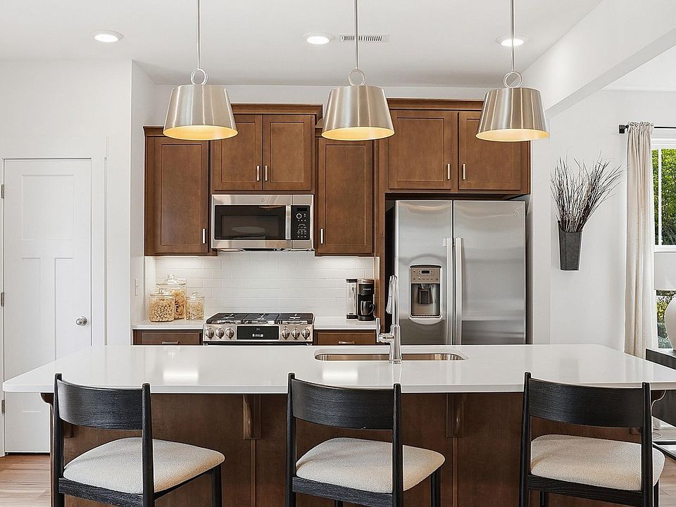 Exceptional kitchen featuring a spacious island, eye-catching pendant lights, and modern finishes ne