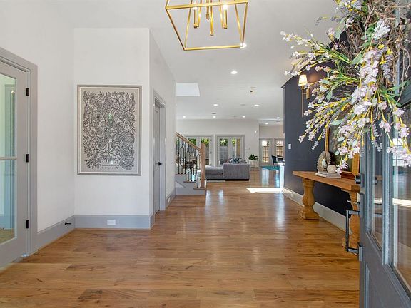 The open foyer is invites you with wood floors and designer lighting. The study/secondary bedroom is to the left.