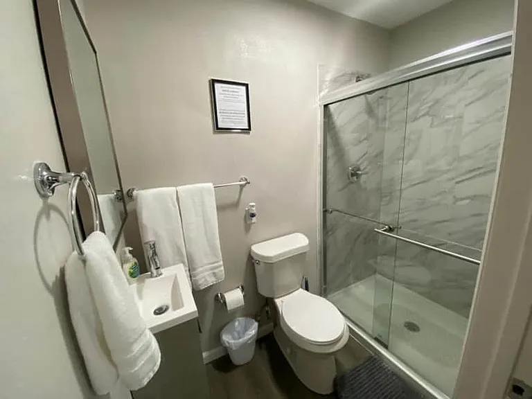 Impeccable bathroom with shower, toilet, sink & towel set