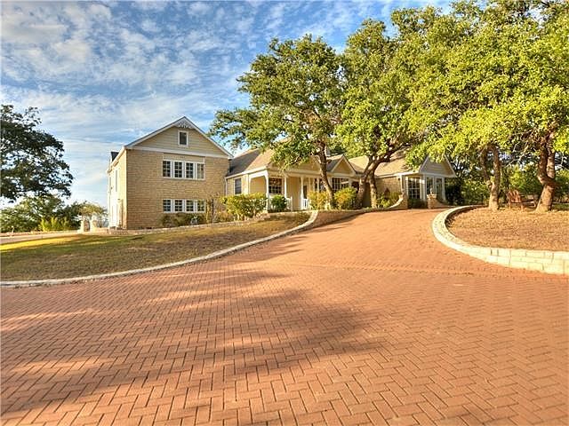 Impressive entry with brick paved circular driveway and oaks.