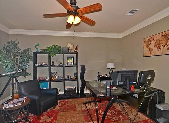 Spacious study at entry with French doors, crown molding, hand scraped wide plank hardwood flooring