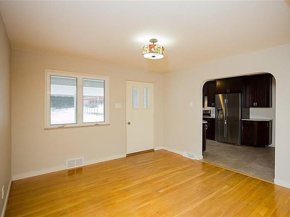 The dining room offers character and charm with the curved archways and gleaming hardwood flooring. Door leads to fenced yard an