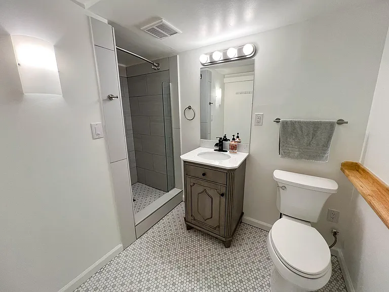 Bathroom, with porcelain floor tile, premium vanity, and full-tiled shower