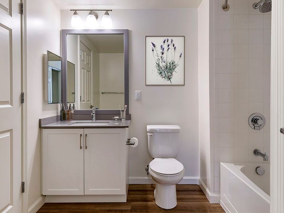 Renovated II bath with grey quartz countertops, white cabinetry, and hard surface flooring