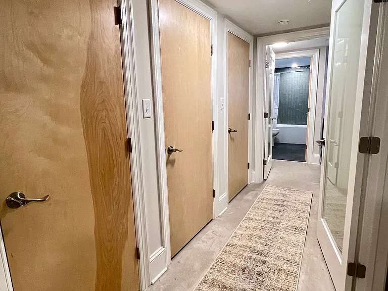 Bedroom level hallway. HVAC closet, washer/dryer closet, storage closet on left side from near to far.