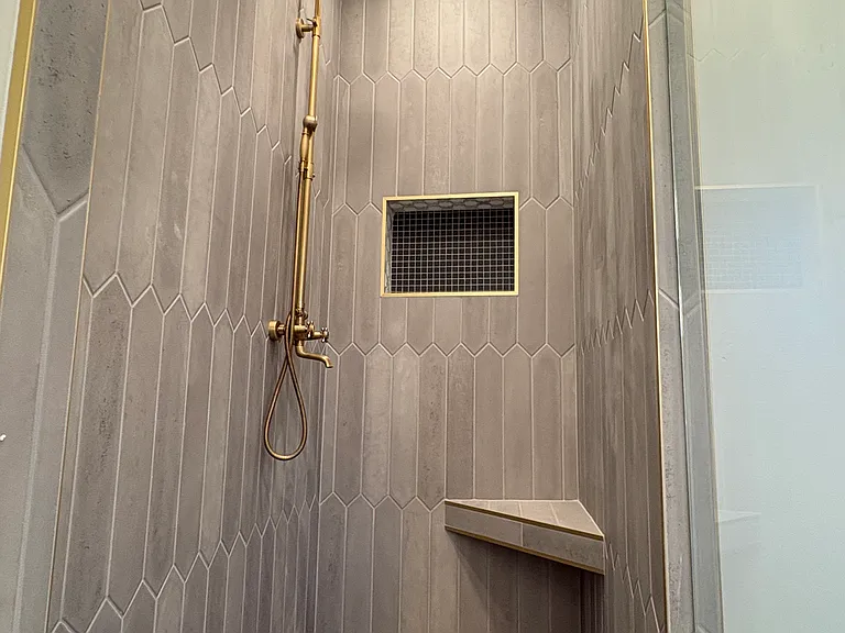Luxury concrete tile, mosaic shower floor, built in comfort shower seat. Dual-head shower