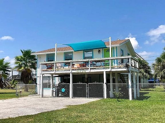 Front view of home with nice deck space to catch sea breezes and fully fenced yard.