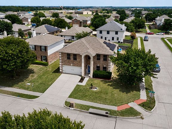 Two-story residence featuring a brick and siding exterior, an attached garage, and a concrete driveway