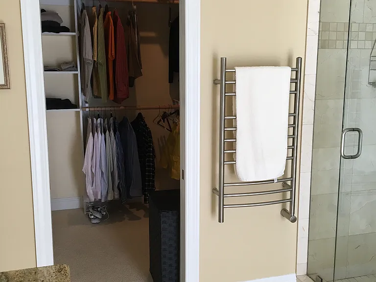 Heated towel rack & walk in closet entry from primary bathroom. Heated radiant tile floor.