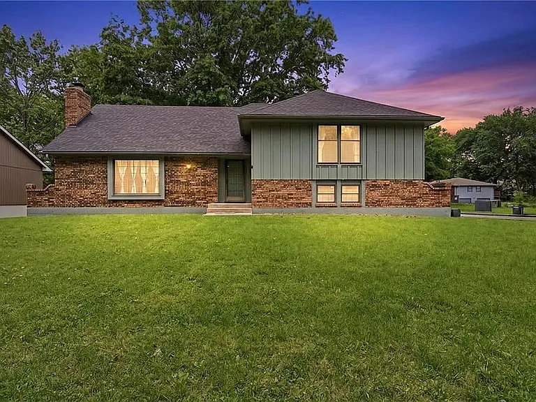 Beautiful twilight exterior showcasing the home's inviting curb appeal, spacious front yard, and peaceful neighborhood atmosphere perfect for relaxing stays near Kansas City.
