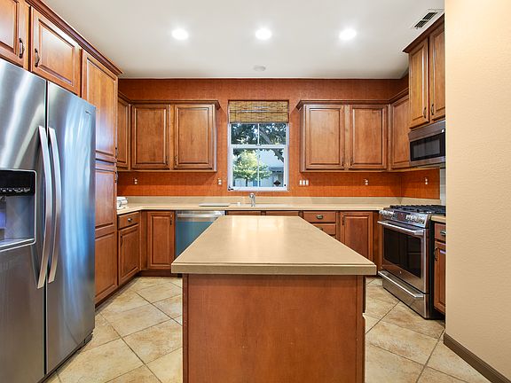 Side by side fridge also newer. Kitchen island for food preparation.