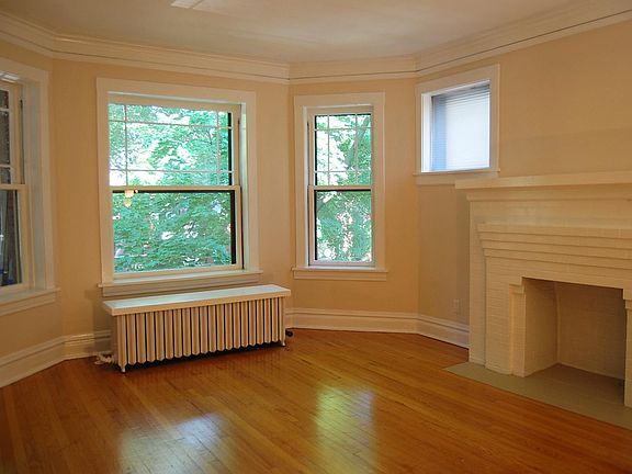 Living Room with restored windows and decorative fireplace. Oak floors.