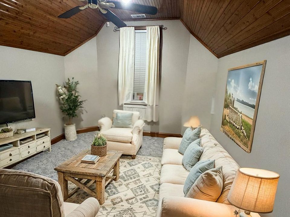 High, vaulted, ceilings, custom woodwork, gas fireplace with original brick/custom mantle/hearth, ceiling fan, LED lighting, open floorplan to kitchen and dining area.