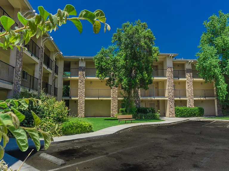 Lush landscaping and shaded walkways create a welcoming place to call home.