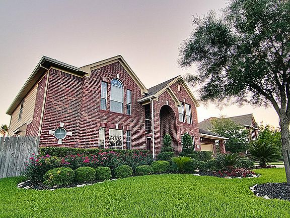 Stunning Red brick with stone details and manicured landscaping.