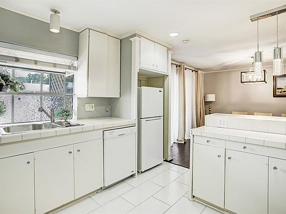 Kitchen with recessed lighting, breakfast bar and tile flooring.