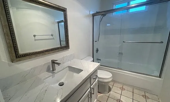 Guest bathroom door view with tub, shower, sliding doors and new fixtures and mirror.