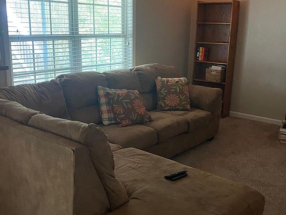 Living area - has sectional and two side chairs - shelf unit - entertainment center including TV.
