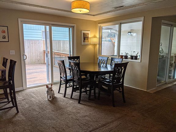 Dining room. Two sliding doors to access backyard with one covered concrete patio and one uncovered wood deck.